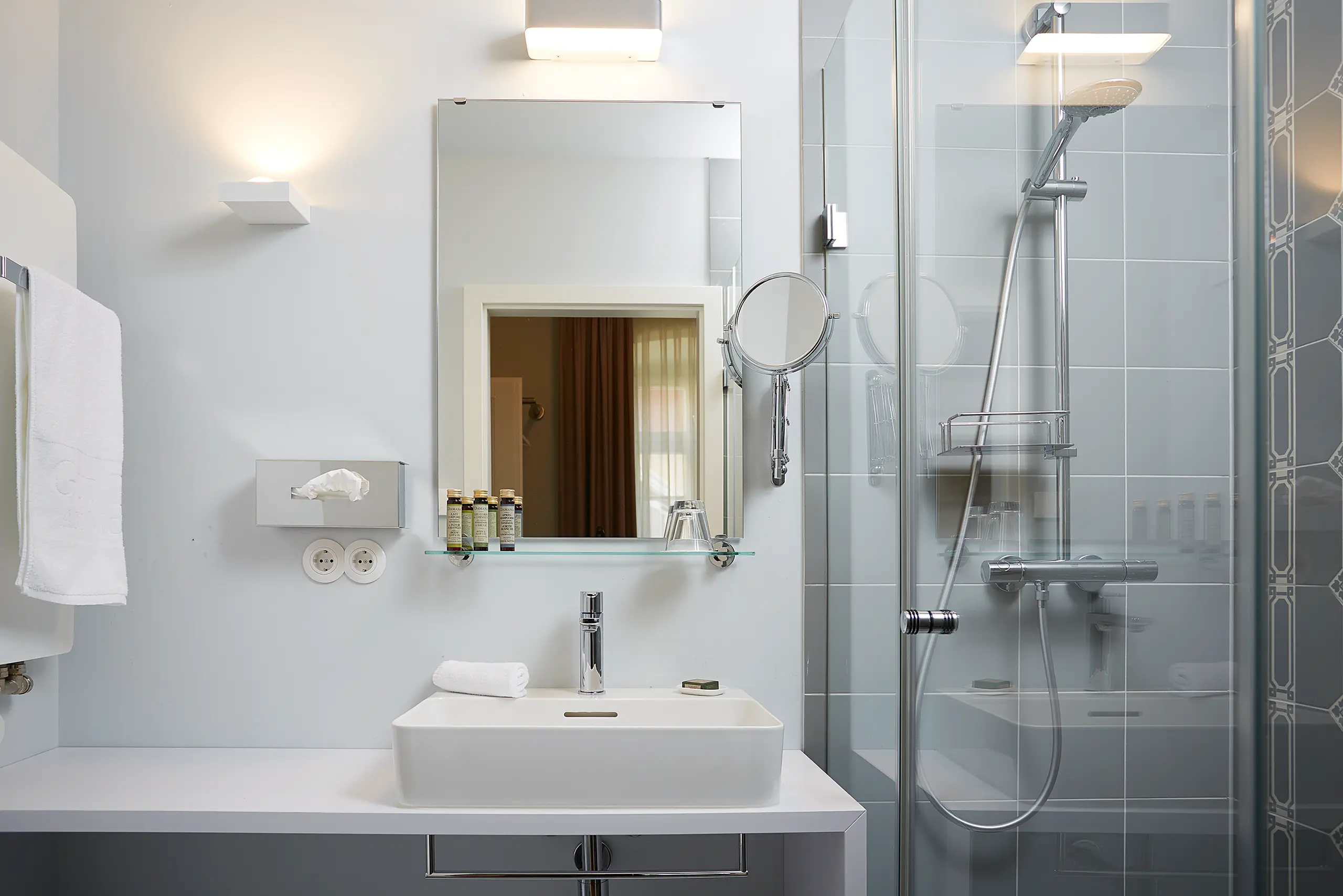 Modernes Badezimmer mit Waschtisch, Spiegel und Glasdusche