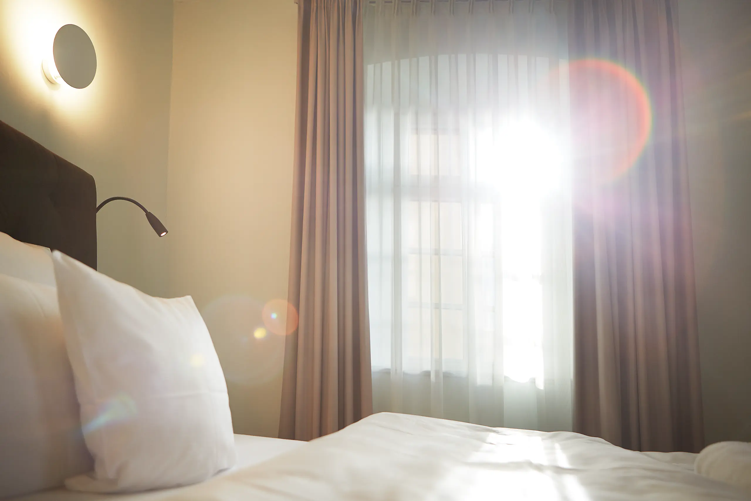 Doppelbett mit weißer Bettwäsche am Fenster in Standard-Zimmer 1 im Fachwerkhaus