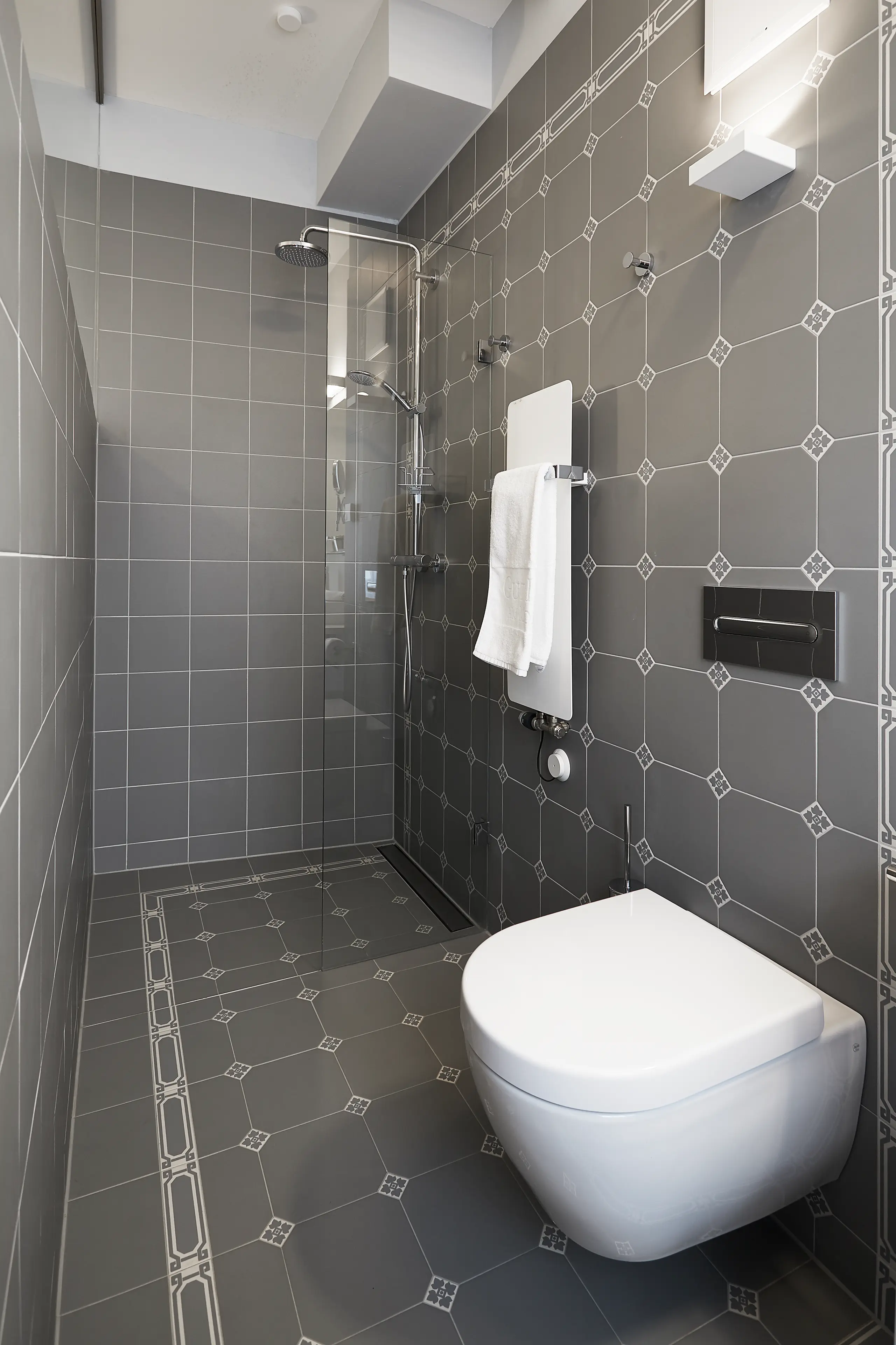 Badezimmer in Standard-Zimmer 3 im Fachwerkhaus mit grauen Fliesen, Dusche und WC