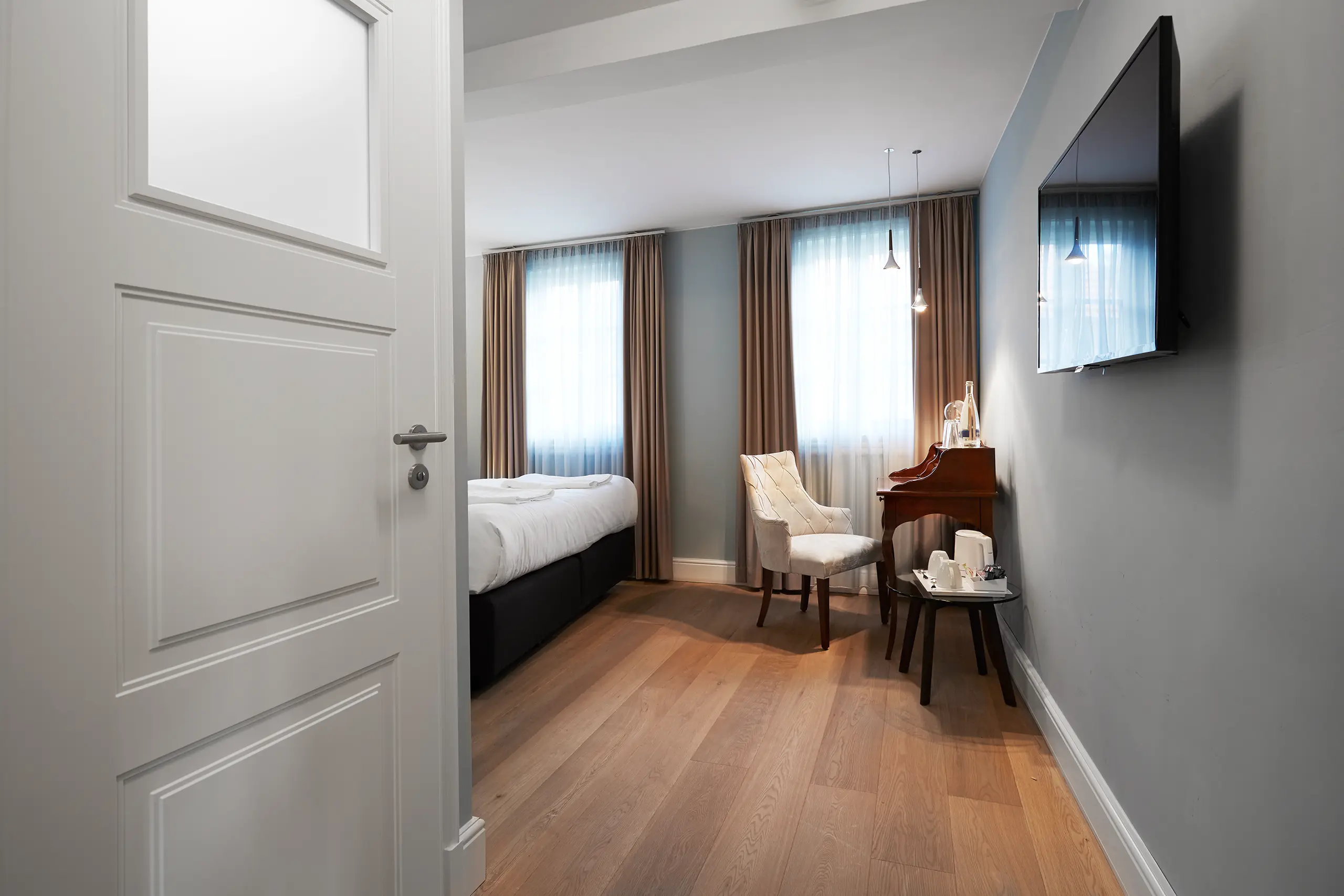 Blick durch die Zimmertür auf Standard-Zimmer 4 im Fachwerkhaus mit Bett und Schreibtisch