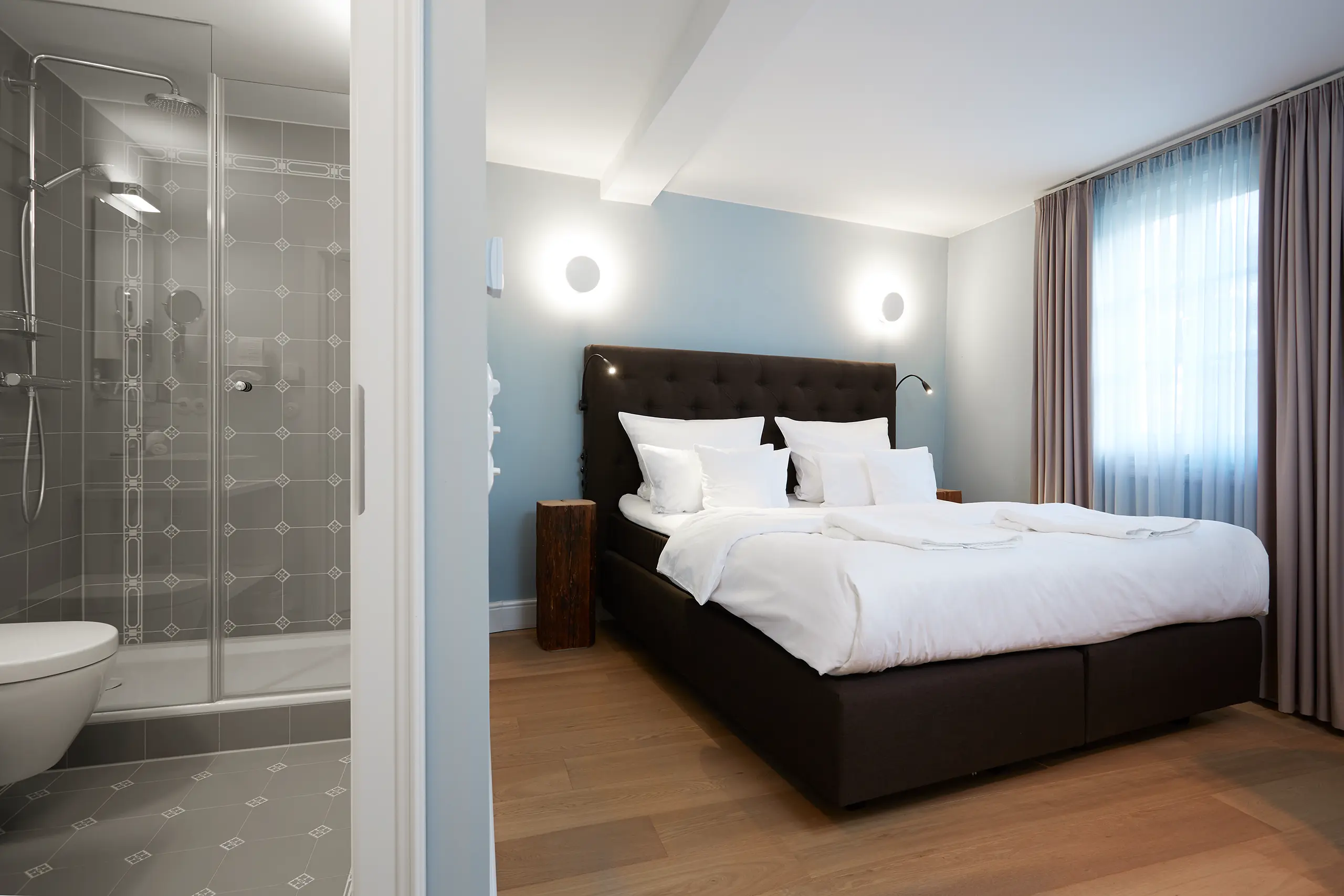 Standard-Zimmer 4 im Fachwerkhaus mit Doppelbett, Vorhängen und Blick ins Bad