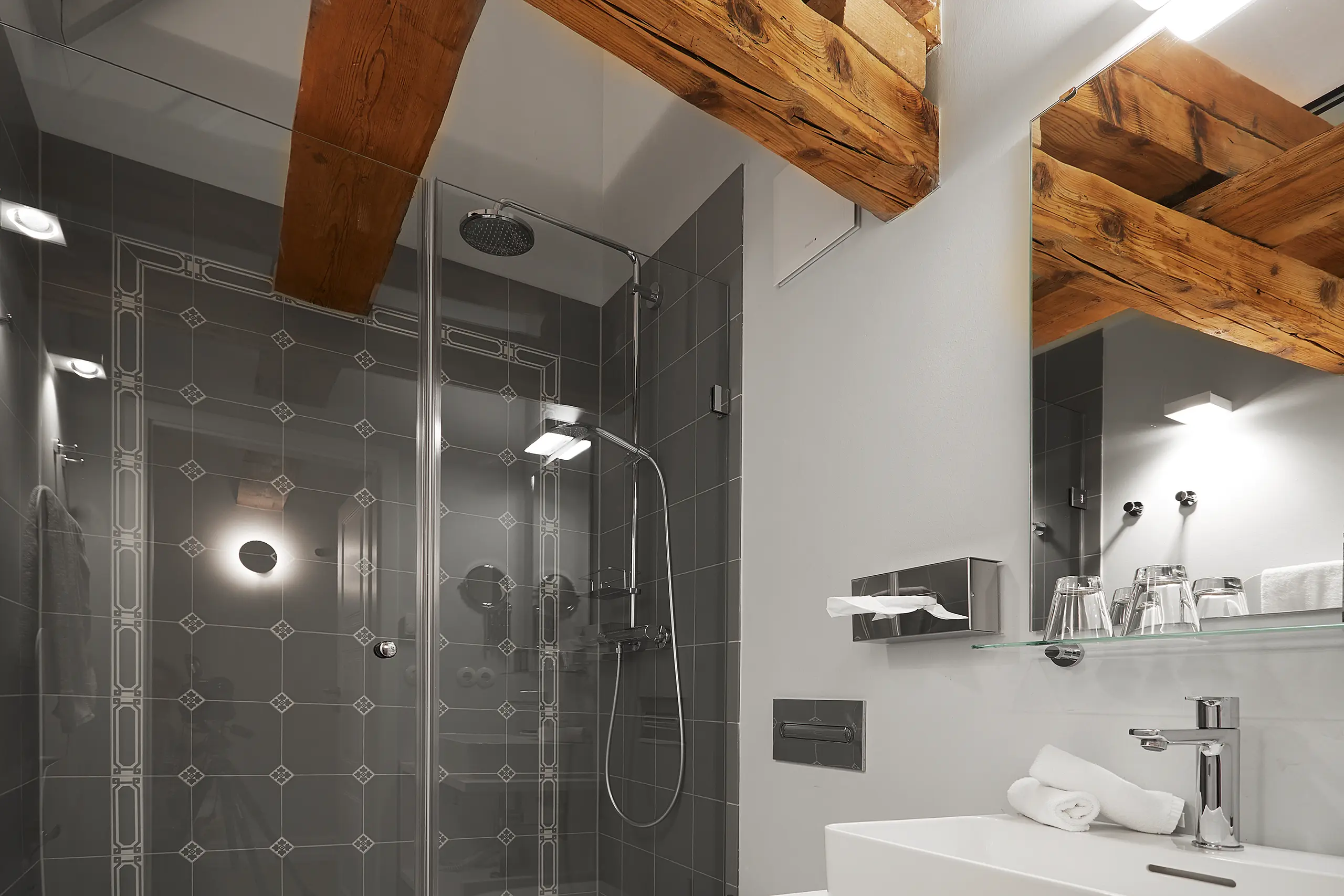 Glasdusche mit Regenbrause unter Holzbalken in Zimmer 8 im Fachwerkhaus