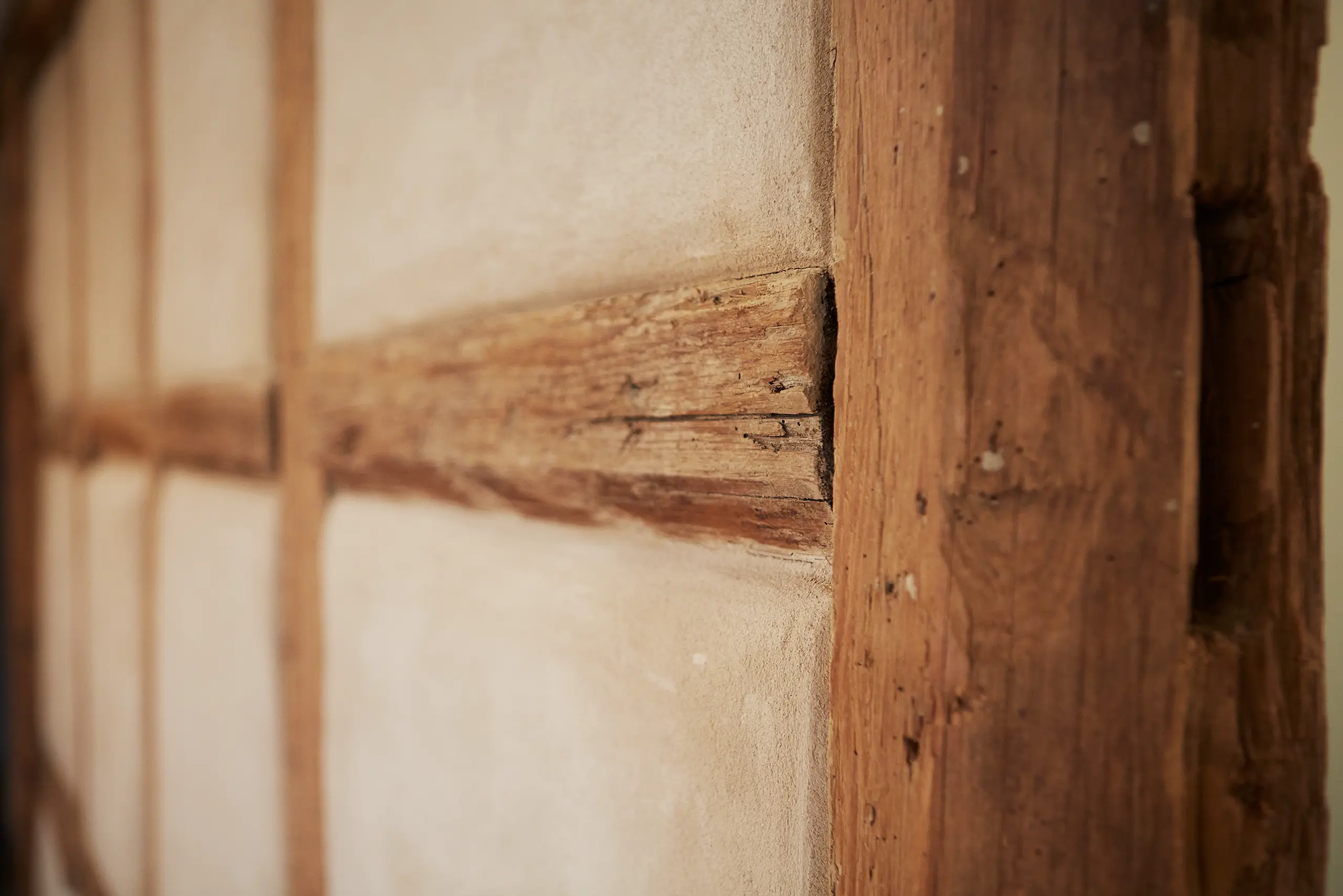 Nahaufnahme der historischen Fachwerkbalken mit Lehmgefach in Zimmer 6