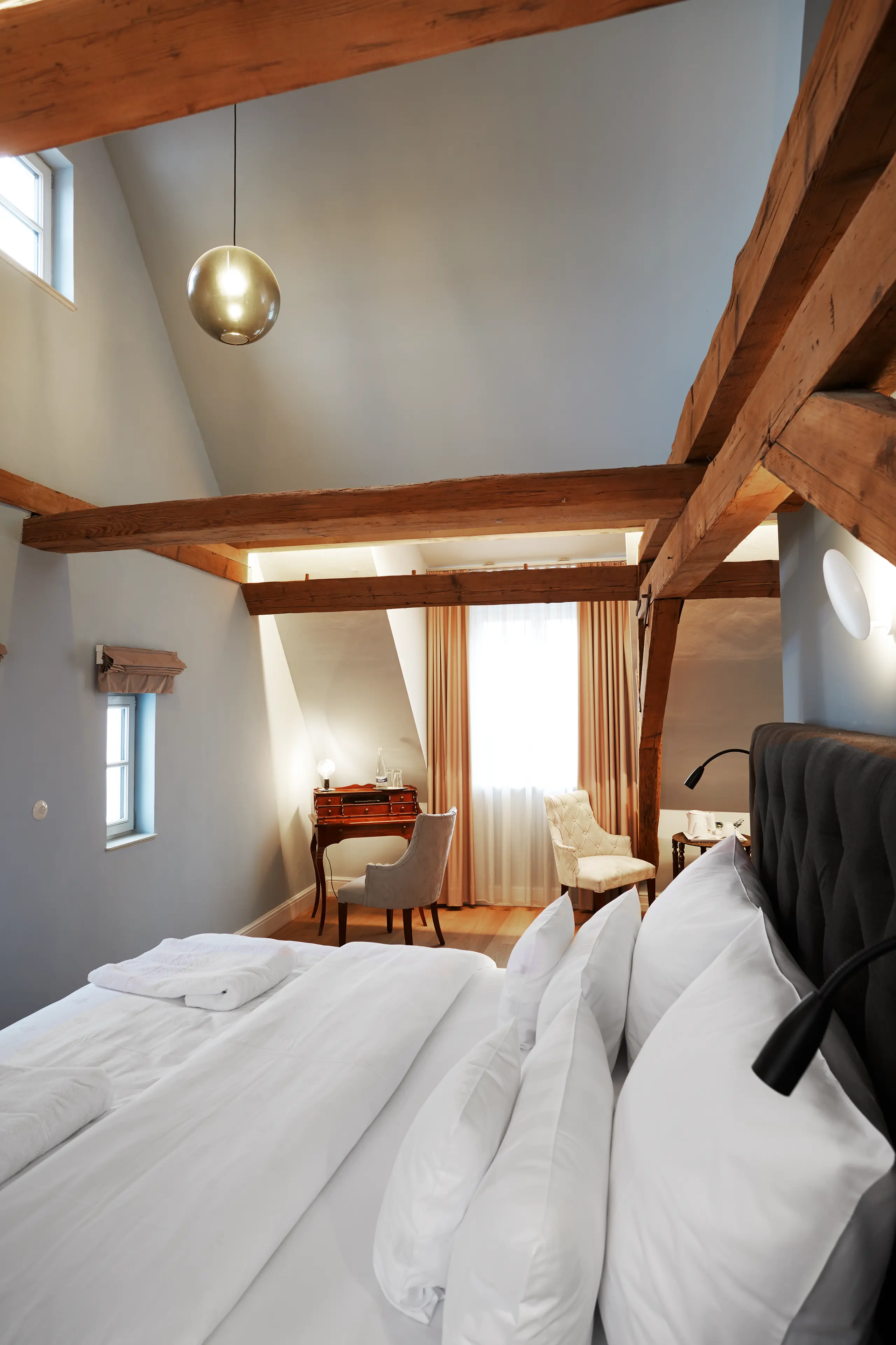 Doppelbett mit weißer Bettwäsche unter Holzbalken in Komfort-Zimmer 9 im Fachwerkhaus