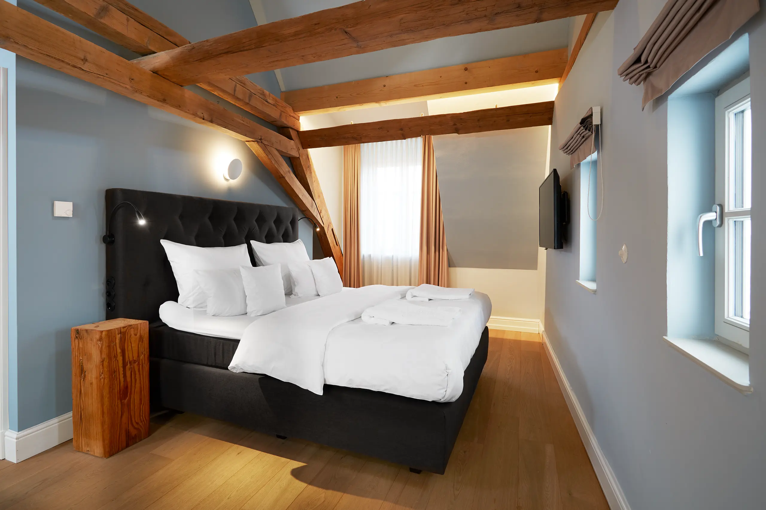 Komfort-Zimmer 9 im Fachwerkhaus mit Doppelbett unter sichtbaren Holzbalken