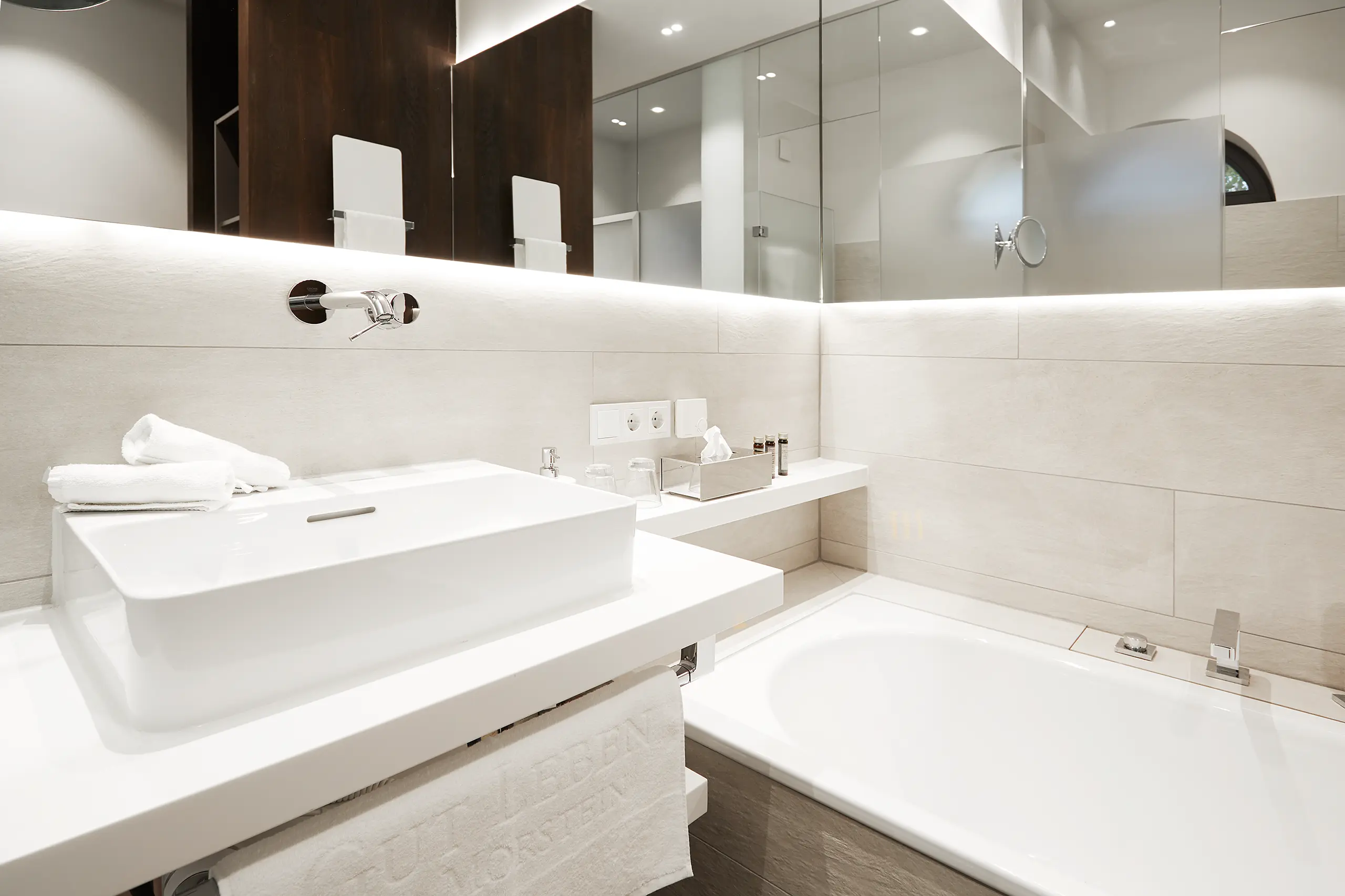 Waschtisch mit Aufsatzbecken und Badewanne im Superior-Zimmer in der Scheune