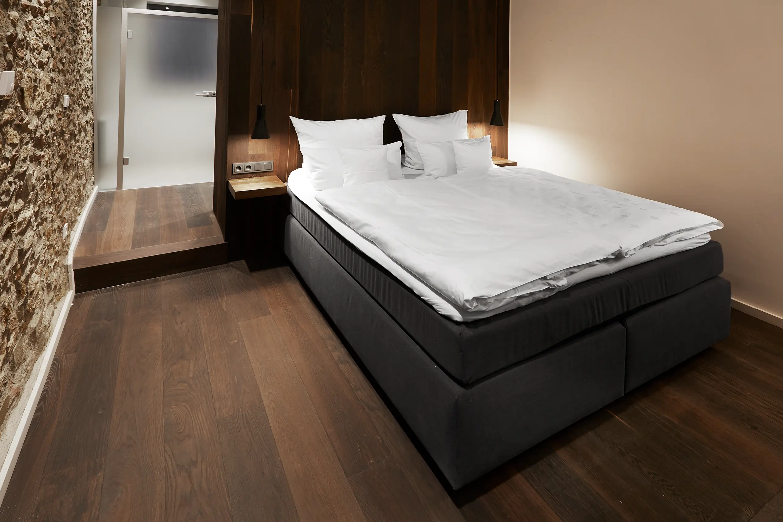 Superior-Zimmer in der Scheune mit Doppelbett, Natursteinwand und dunklem Holzboden