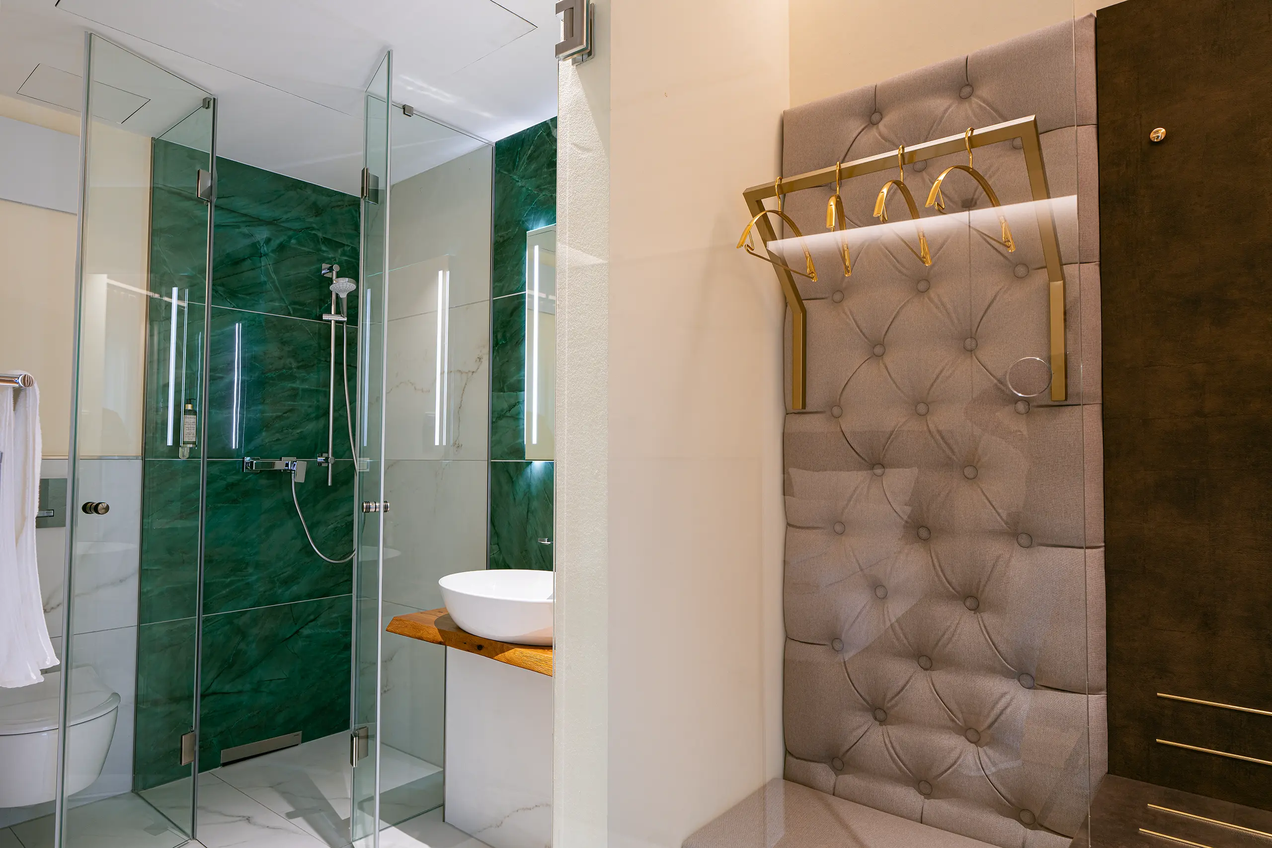 Badezimmer in Zimmer 23 im Neubau mit grüner Marmordusche und Glaswand