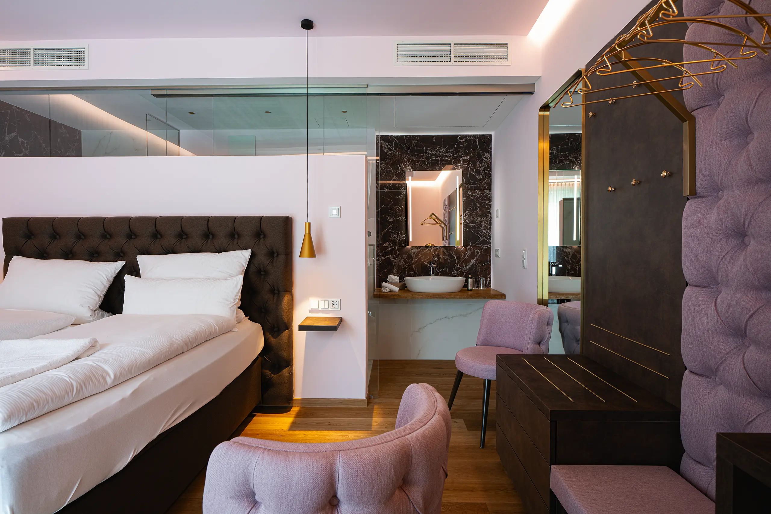 Superior-Zimmer im Neubau mit Doppelbett, Sessel und indirekter Beleuchtung