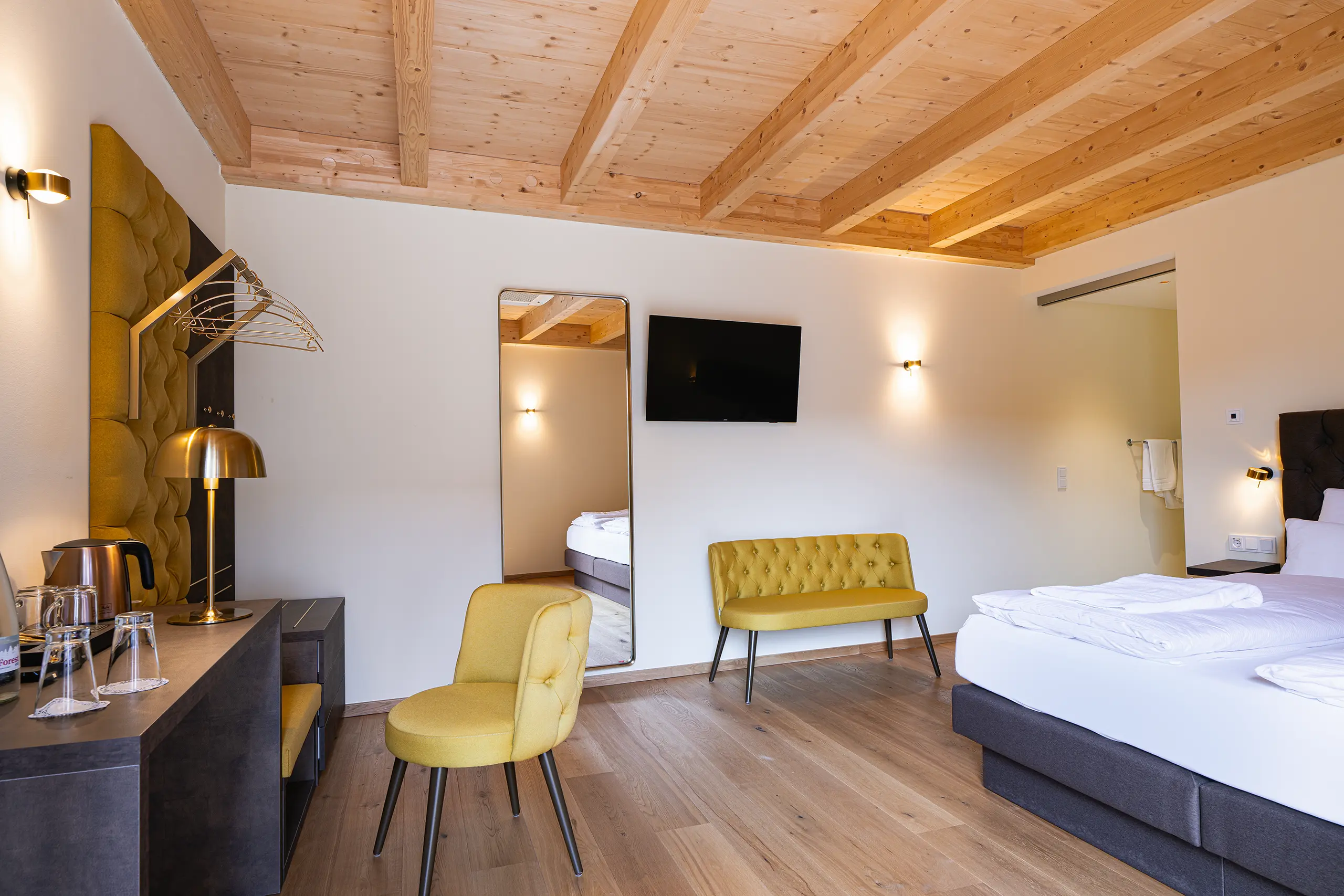 Superior-Zimmer 28 im Neubau mit Doppelbett, Holzdecke und gelbem Sessel