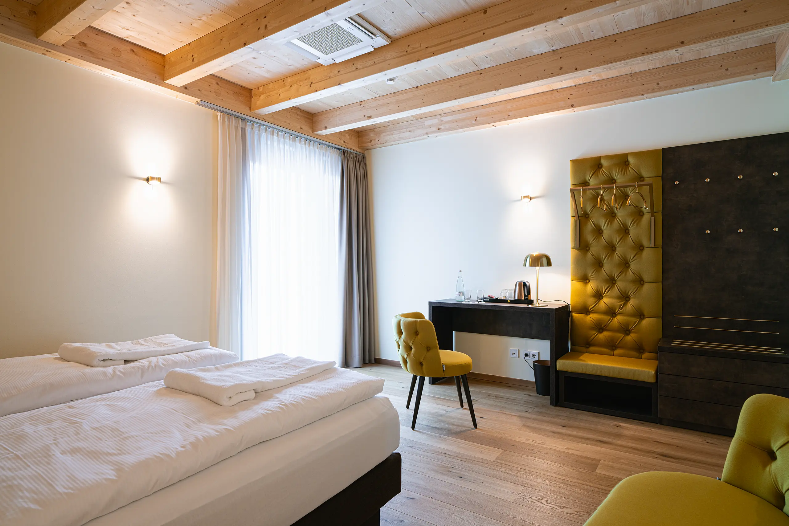 Superior-Zimmer 28 im Neubau mit Doppelbett, Schreibtisch und gelbem Sessel