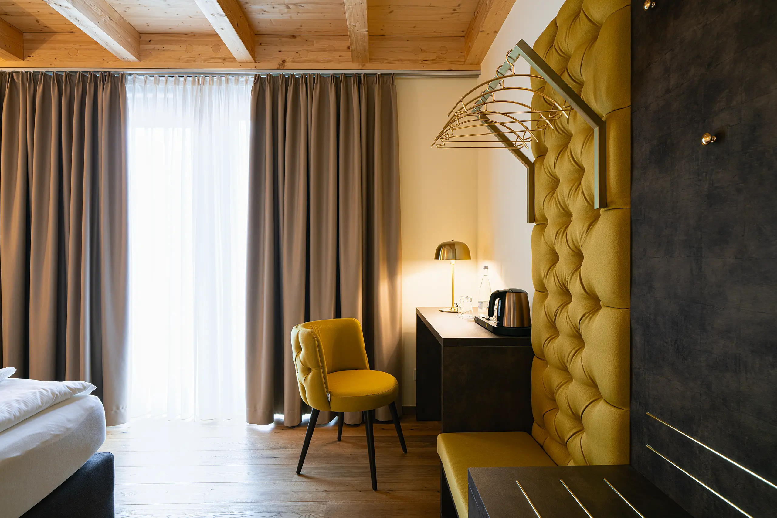 Superior-Zimmer im Neubau mit gelbem Sessel, Kleiderhaken und Fenster