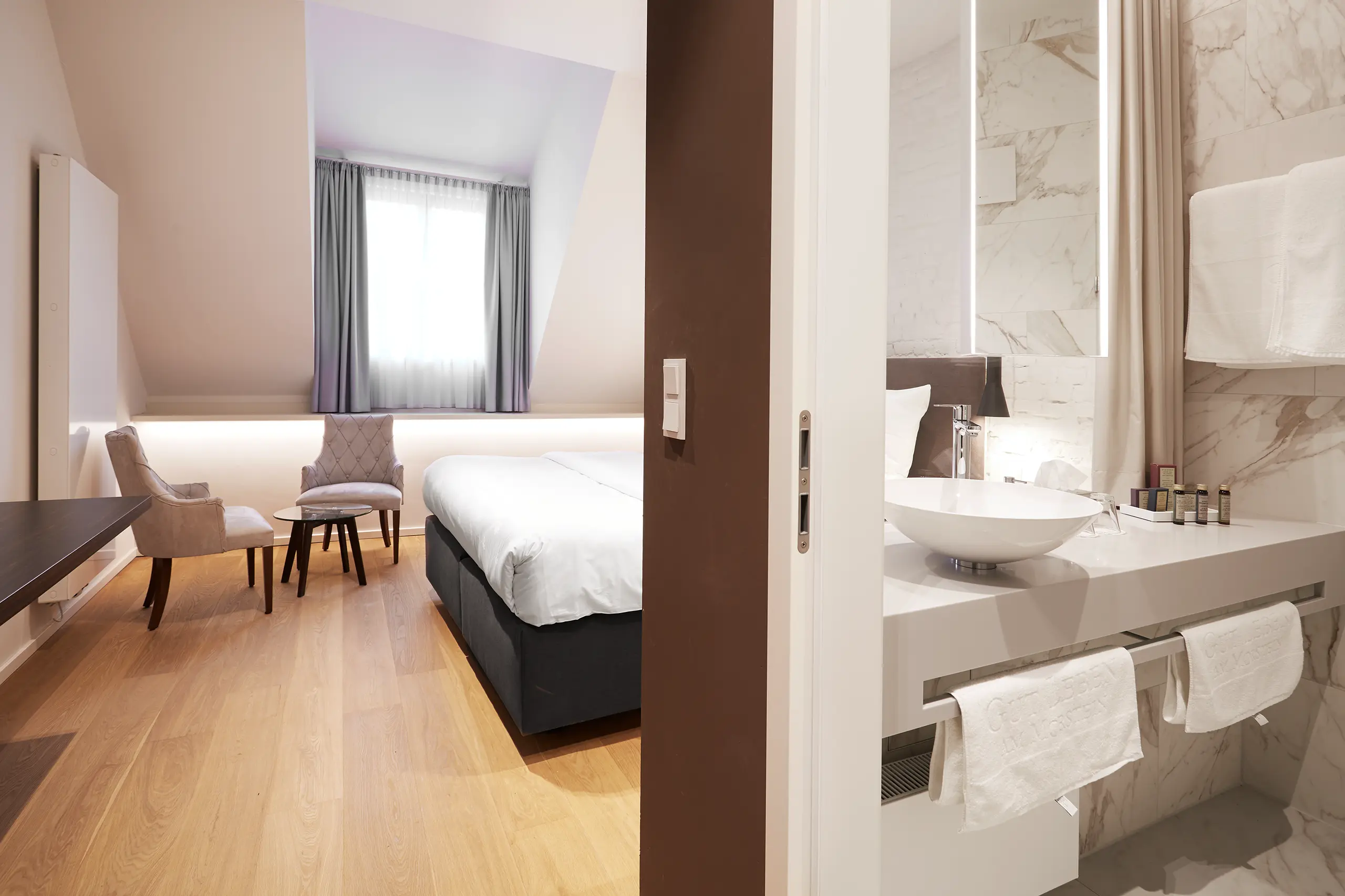 Blick vom Bad ins Superior-Zimmer in der Scheune mit Bett und Sitzecke