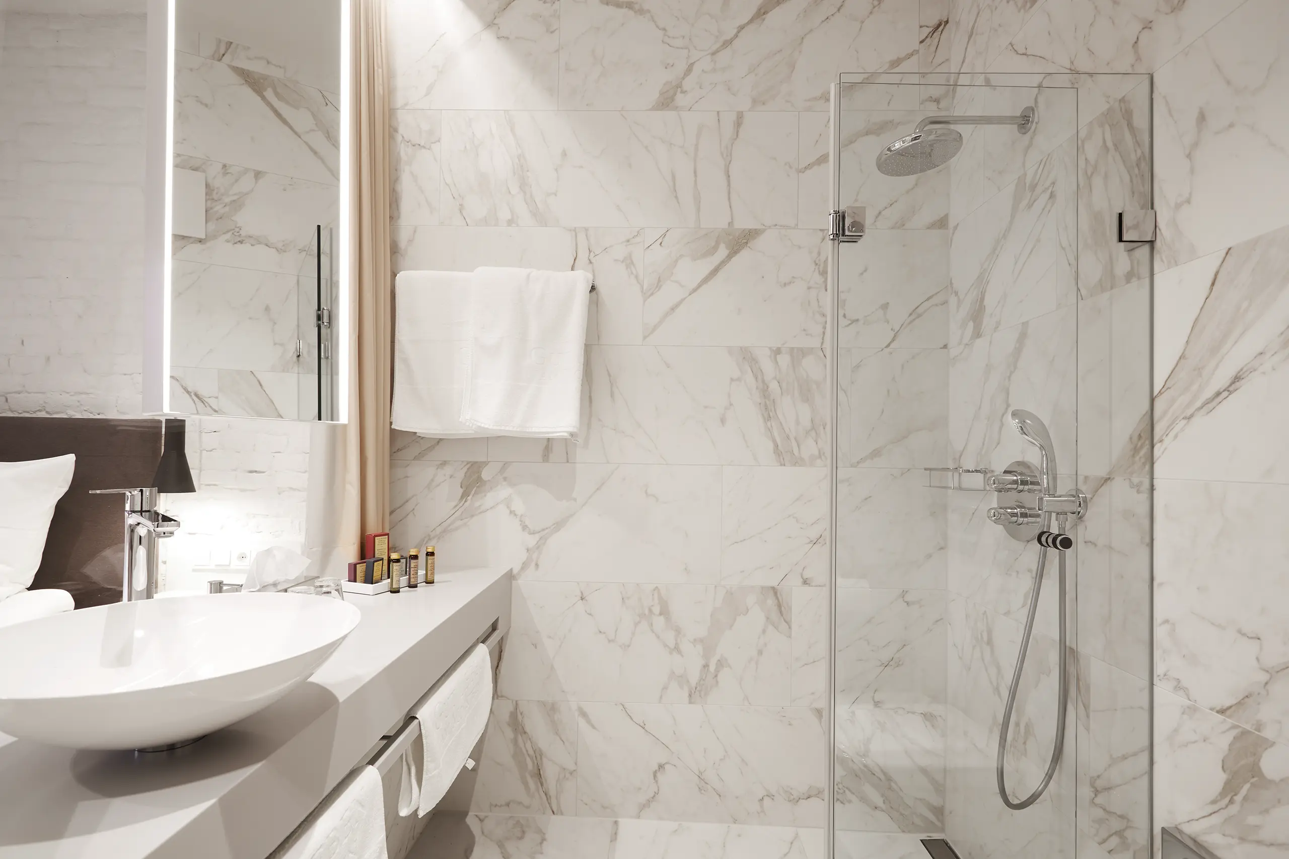 Badezimmer mit Marmorfliesen, Regendusche und Waschtisch im Superior-Zimmer in der Scheune