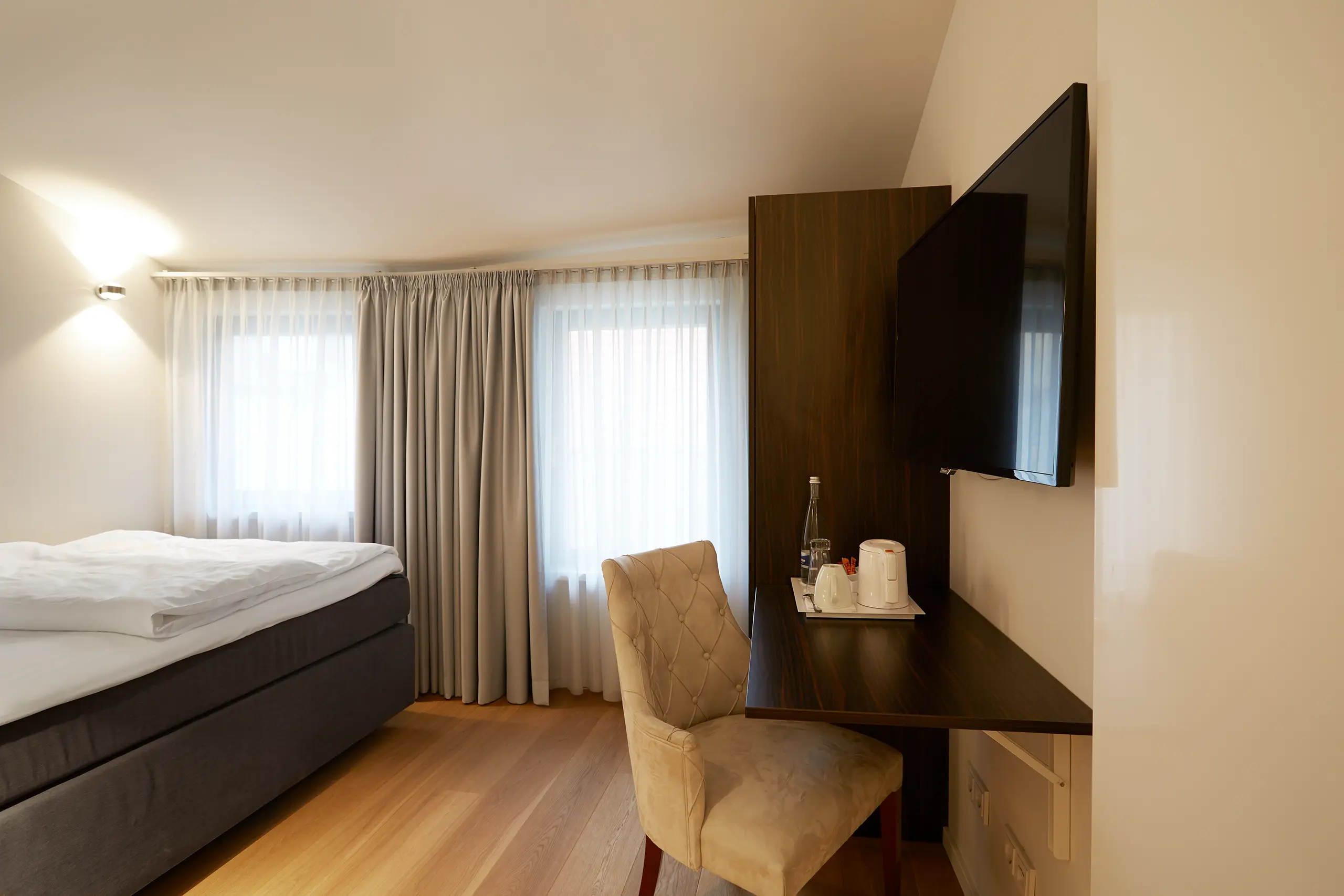 Einzelzimmer Standard in der Remise mit Bett, Schreibtisch und Bildschirm