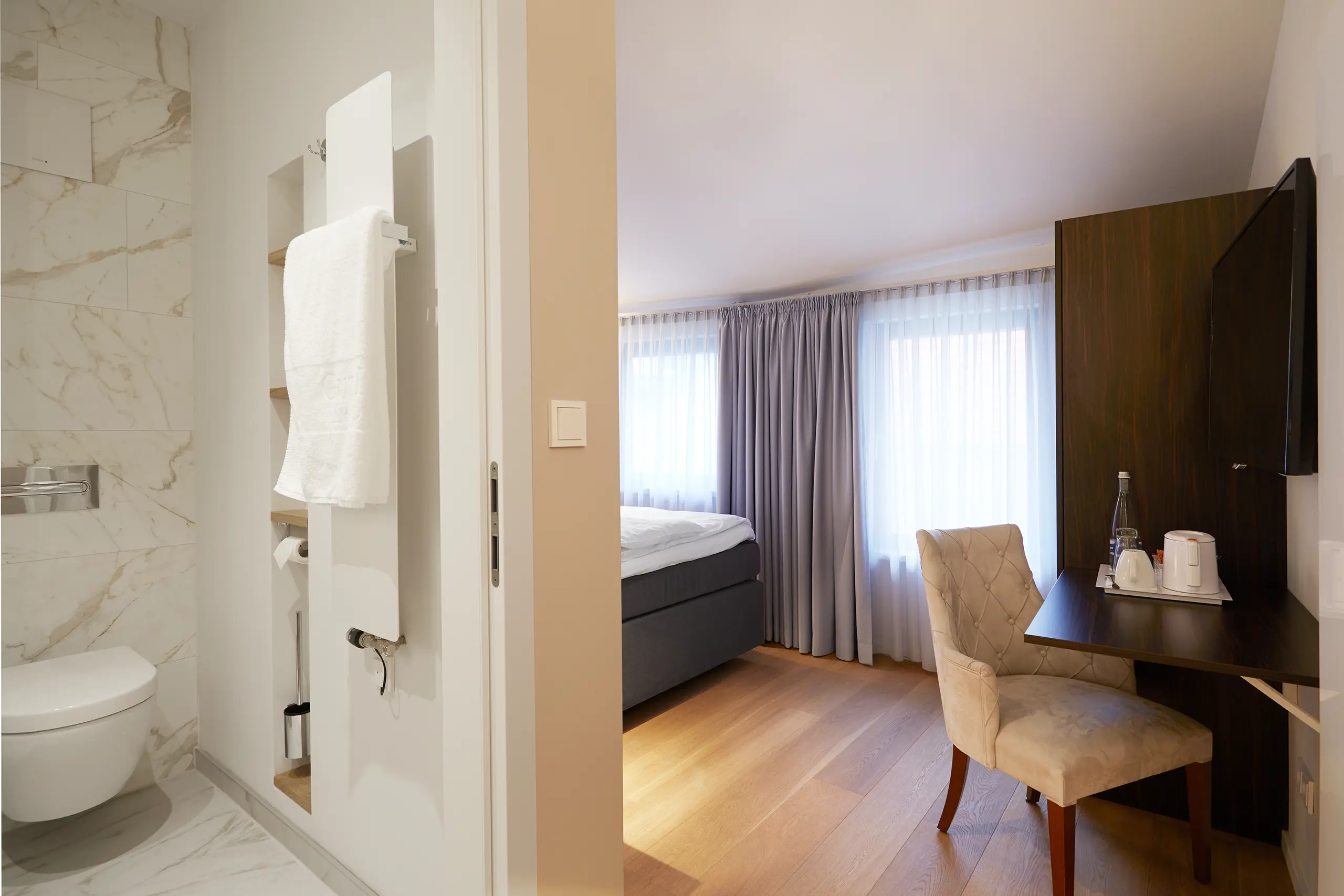 Einzelzimmer Standard in der Remise mit Bett, Sessel und Schreibtisch