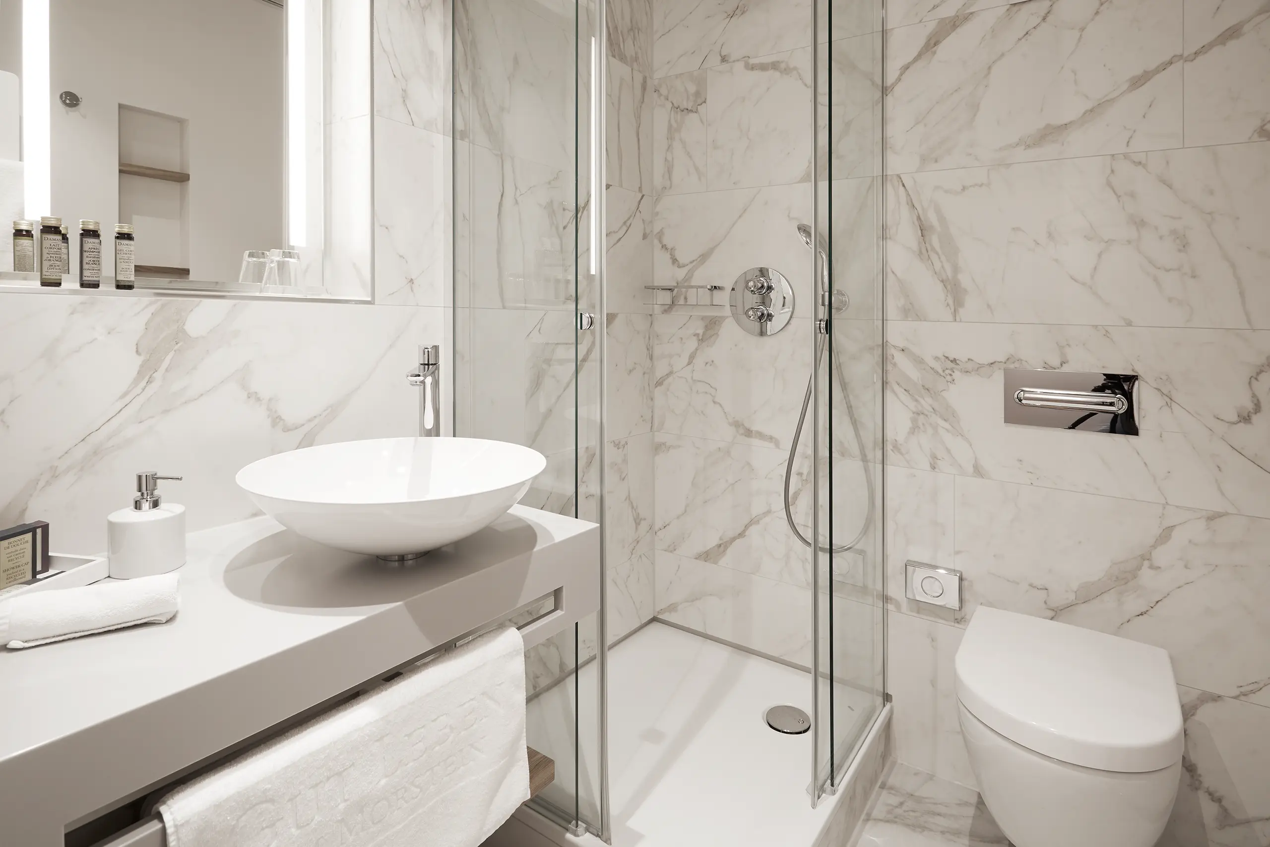 Badezimmer im Einzelzimmer in der Remise mit Marmorfliesen, Waschtisch und Glasdusche