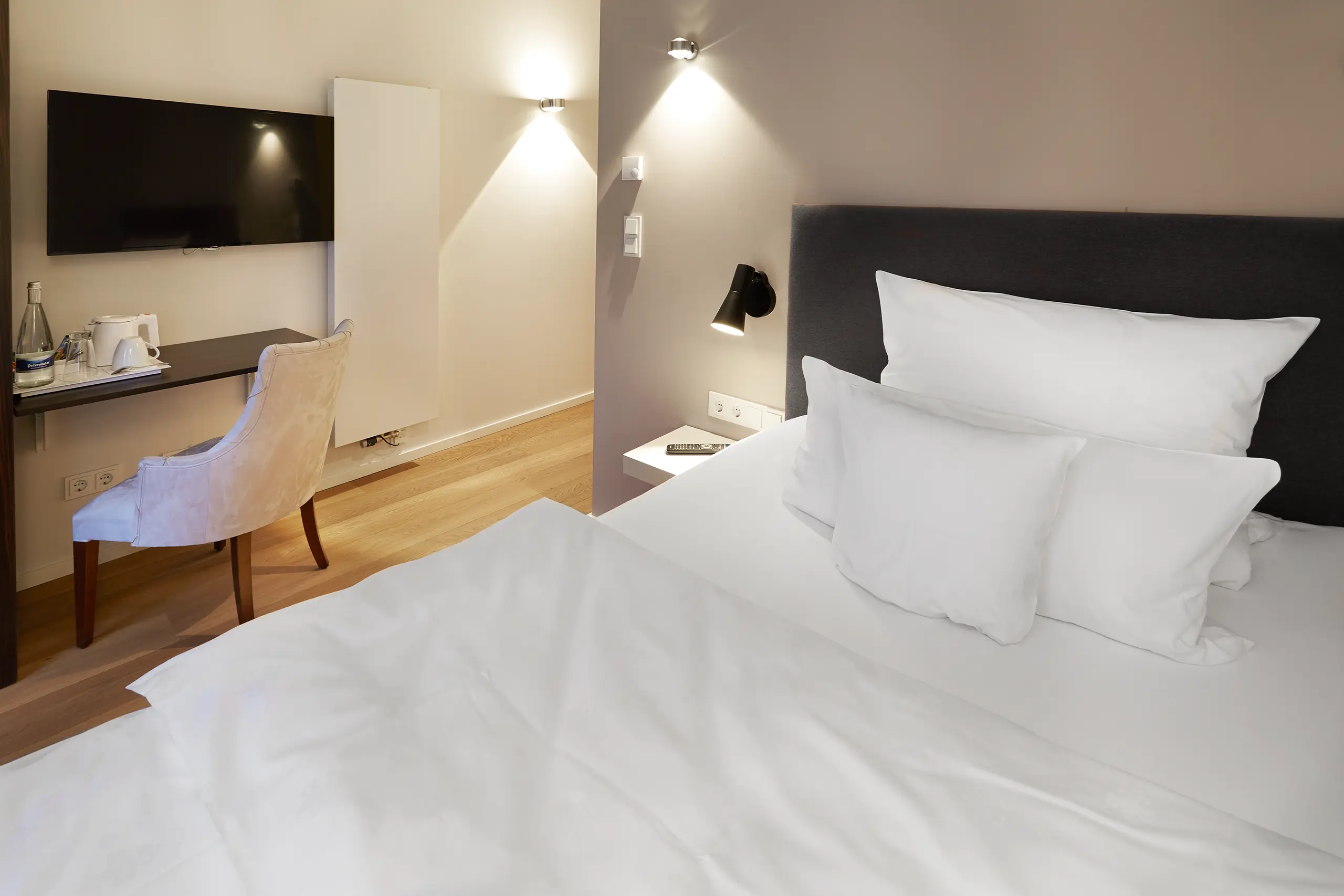 Einzelzimmer Standard in der Remise mit Bett, Schreibtisch, Stuhl und Bildschirm