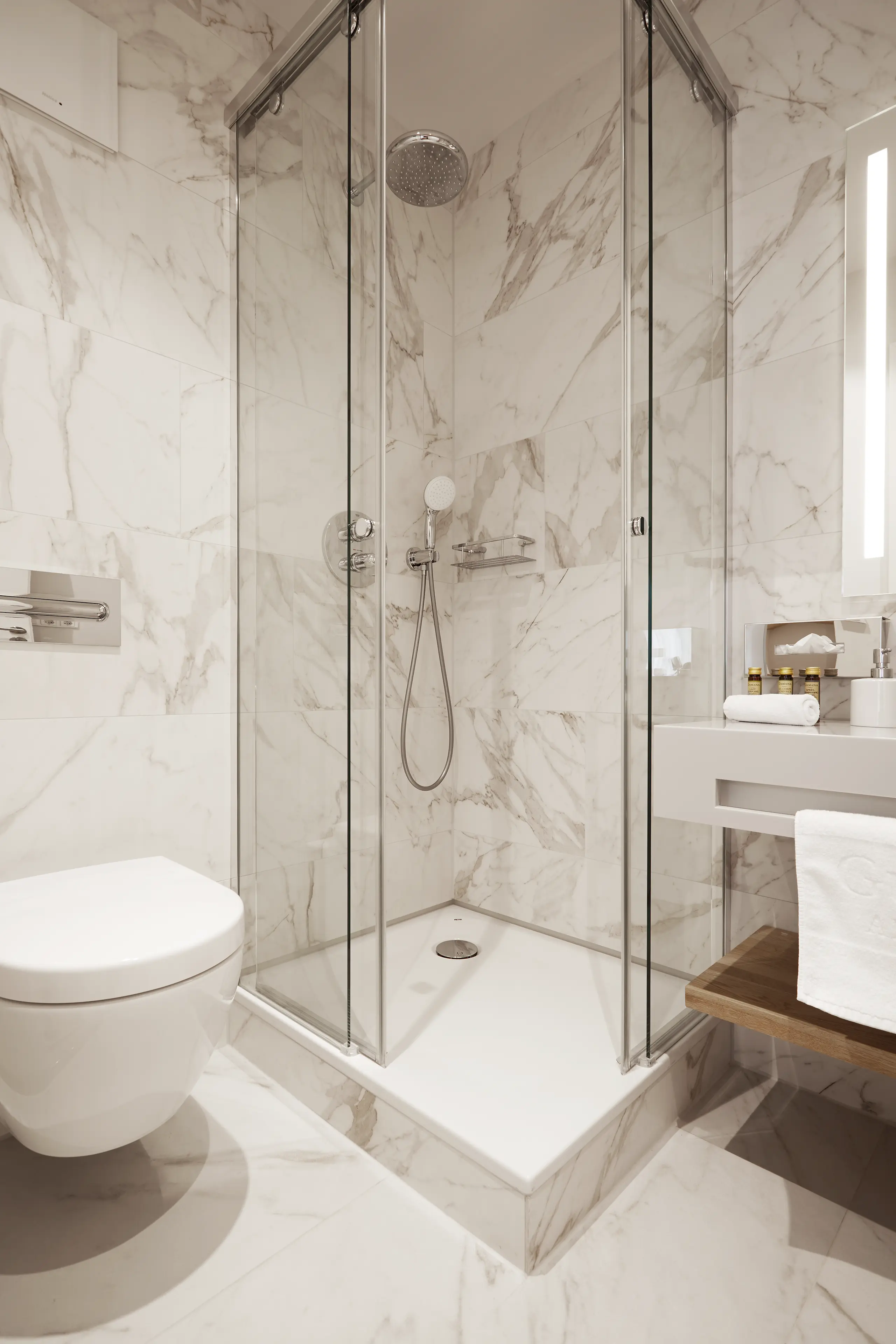 Badezimmer im Einzelzimmer in der Remise mit WC, Glasdusche und Marmorfliesen