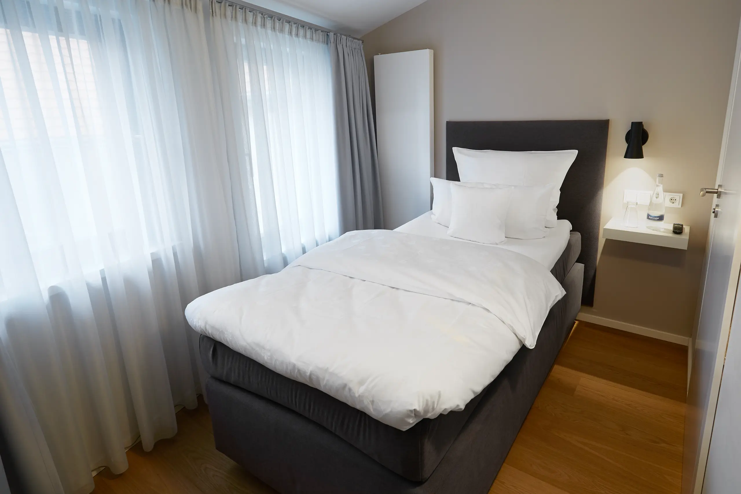 Einzelzimmer Standard in der Remise mit Boxspringbett am Fenster