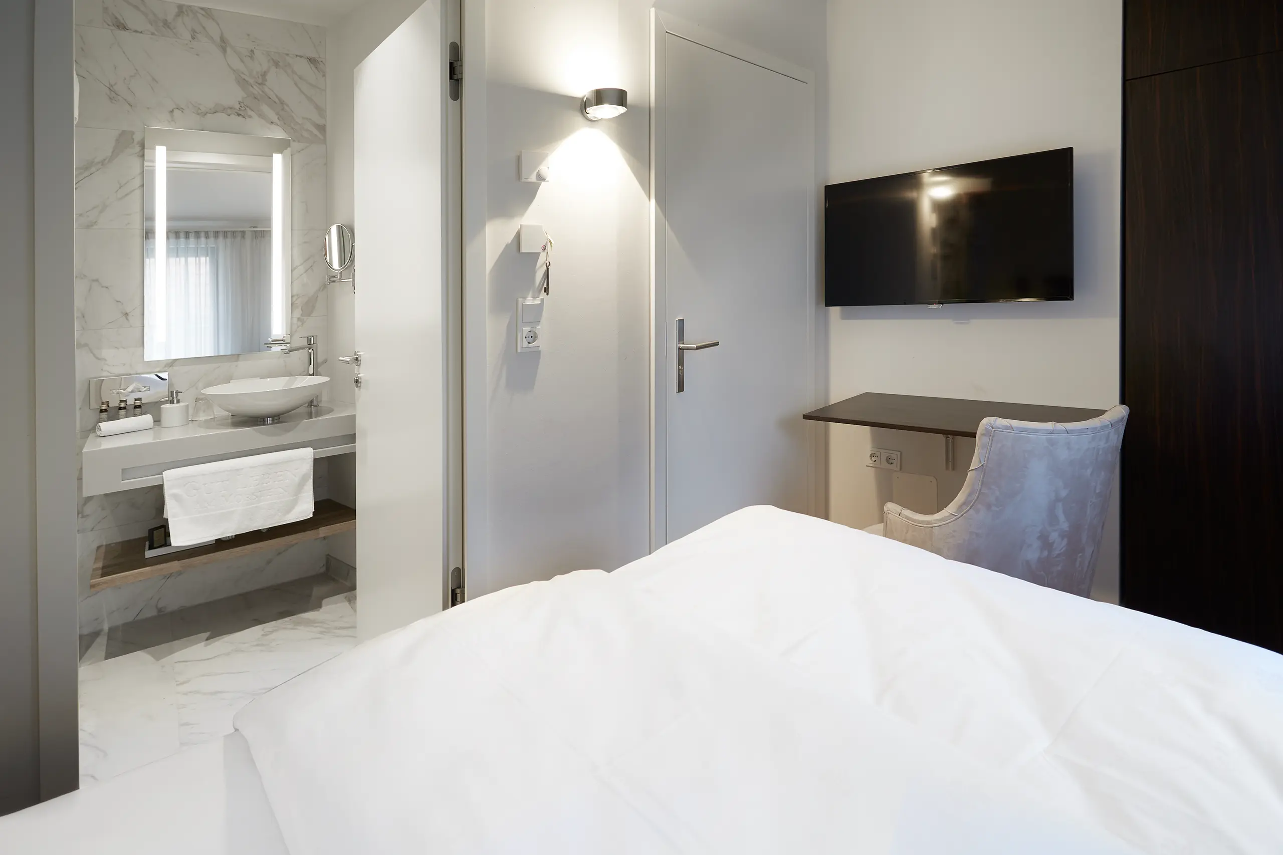 Einzelzimmer Standard in der Remise mit Bett, Bildschirm und Blick ins Bad
