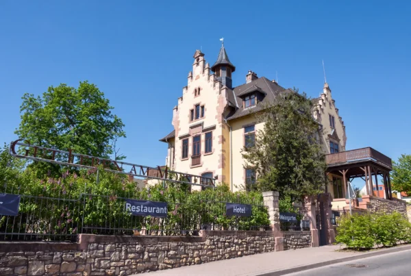 Das Schlösschen von Gut Leben am Morstein mit Turm und Garten unter blauem Himmel